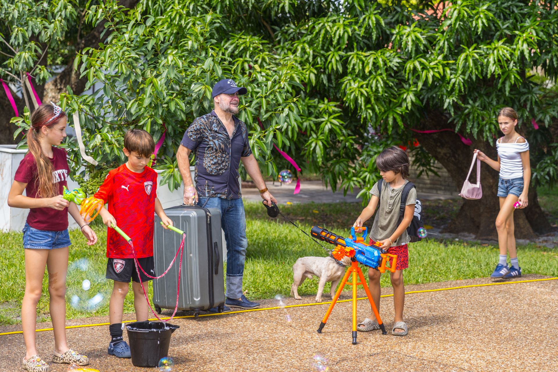 Giant soap bubbles drift over children on the lawn